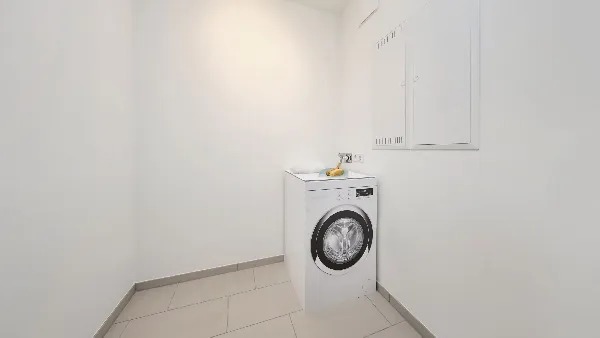 Hauswirtschaftsraum des Musterhauses in UPTOWN Living mit einer Waschmaschine in der Ecke