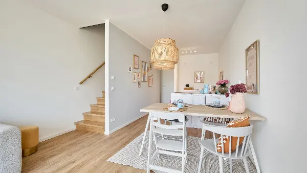 Rechts Esstisch und Küche des Musterhauses in UPTOWN Living, links die Treppe zur nächsten Etage